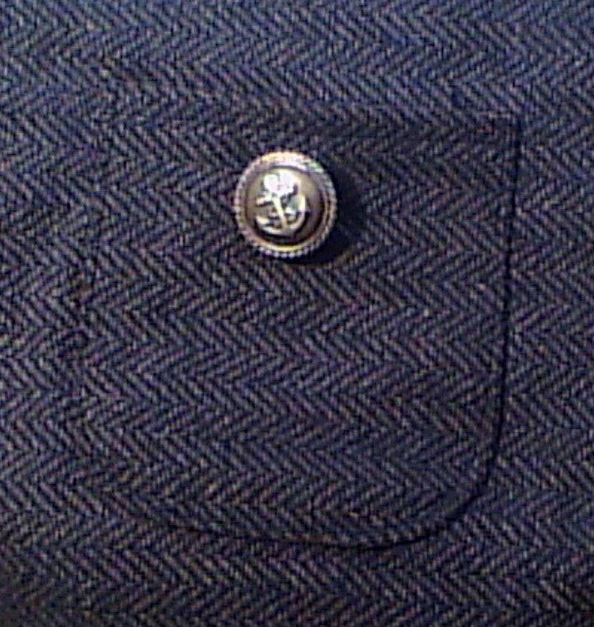 Close-up of the herringbone dog coat pocket with blazer-style button