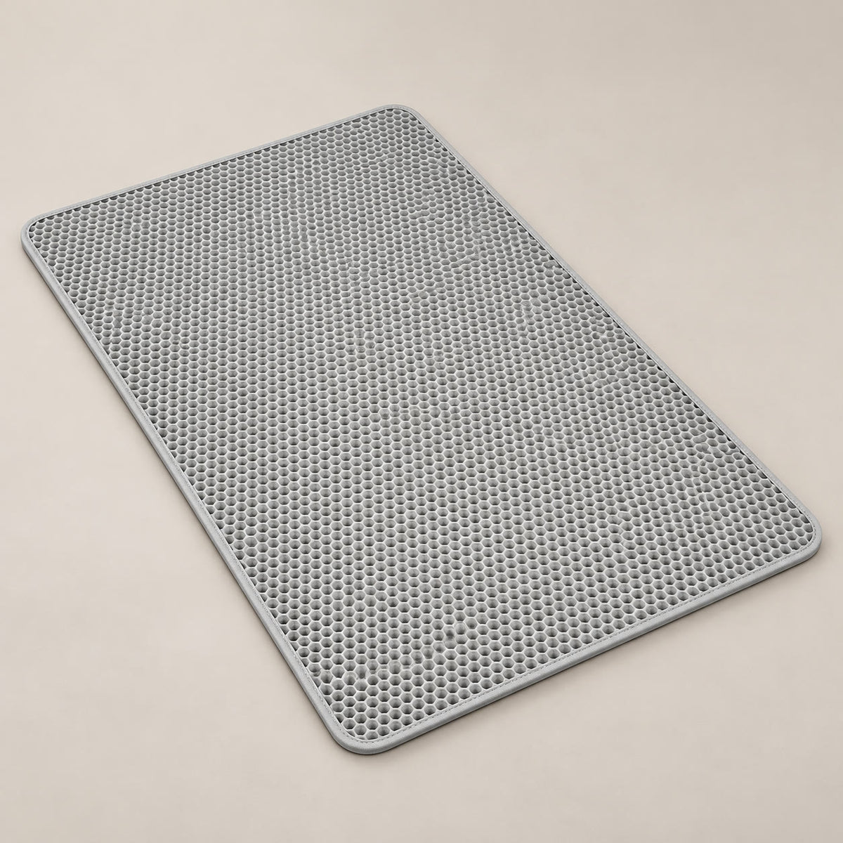 Grey double-layer cat litter mat with honeycomb top - studio photograph on a warm neutral backdrop