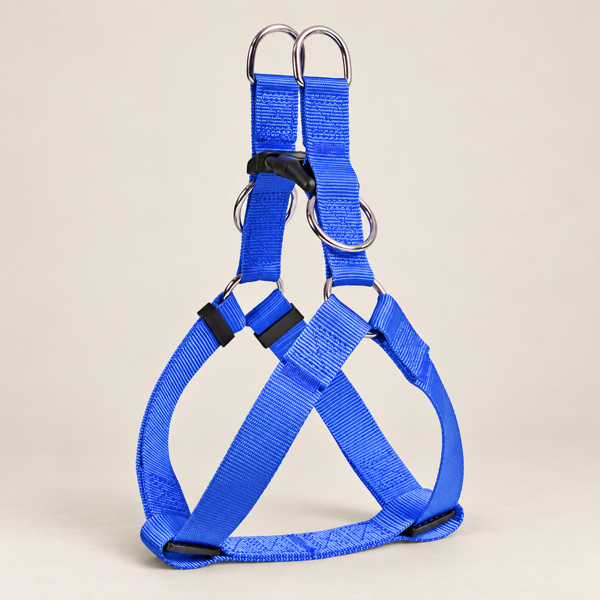 Blue nylon dog harness - studio photograph on a warm neutral backdrop