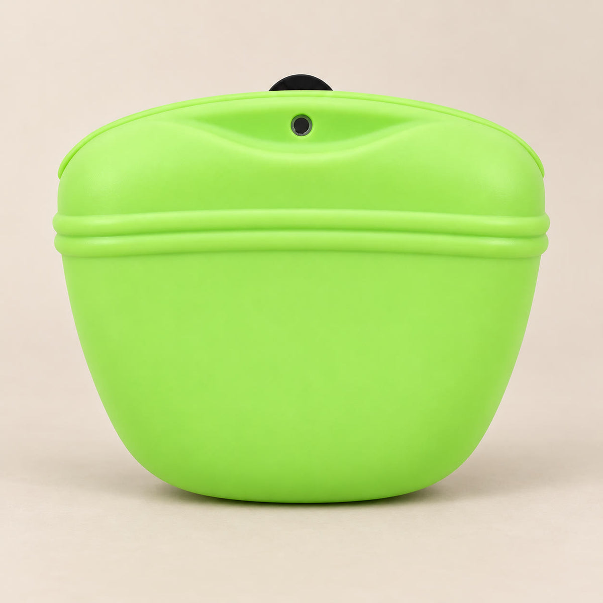 Green silicone dog treat pouch with magnetic opening - studio photograph on a warm neutral backdrop